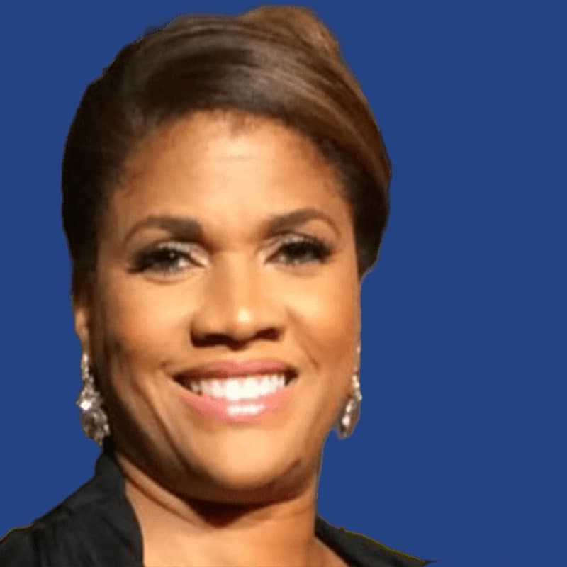 Smiling Black woman with brown hair and silver earrings against a solid blue background.